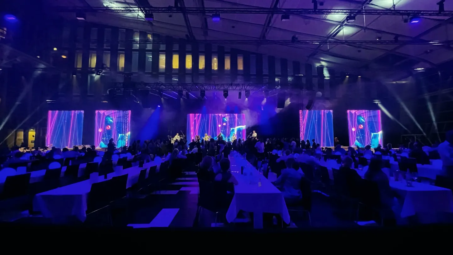 Gemini Music live on stage at a corporate gala – the band in front of LED walls, a full hall of guests